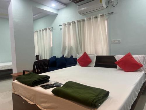 海得拉巴的住宿－Brundavan，一间卧室配有一张带红色和蓝色枕头的大床