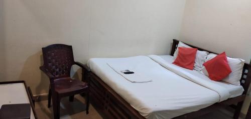 a room with a bed with a chair and a bed sidx sidx sidx at Brundavan in Hyderabad