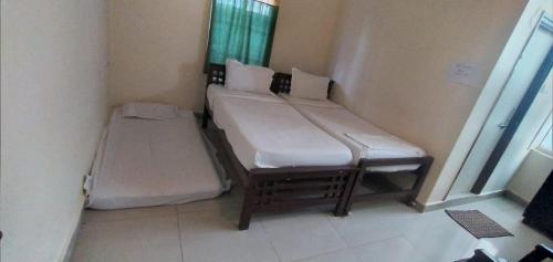 un par de camas en una habitación pequeña en Brundavan en Hyderabad