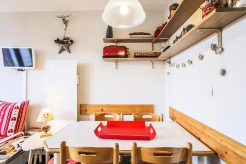 une salle à manger avec une table et des chaises rouges dans l'établissement Résidence Le Hameau du Sauget - maeva Home - Appartement 2 pièces 4 personnes Confort MAE-5604, à La Plagne Tarentaise