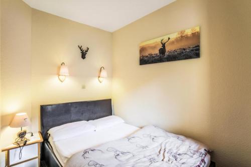 - une chambre avec un lit et deux antilopes sur le mur dans l'établissement Résidence Le Hameau du Sauget - maeva Home - Appartement 2 pièces 4 personnes Confort MAE-5604, à La Plagne Tarentaise