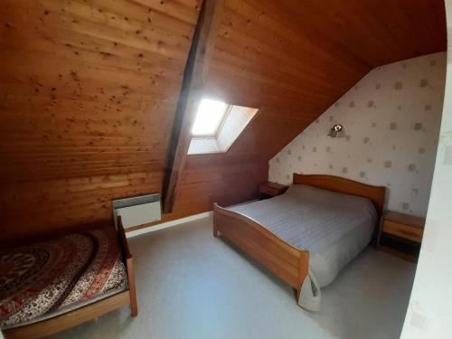 1 dormitorio en el ático con cama y ventana en Gîte de France à Lamazière-Haute 2 épis - Gîte de France 5 personnes 934, 