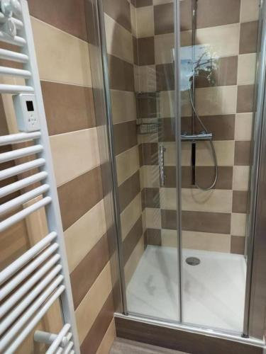 une douche avec une porte vitrée dans une salle de bain dans l'établissement Gîte de France Gratte bruyère 3 épis - Gîte de France 8 personnes MAE-9984, à Sérandon