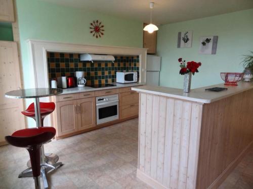 a kitchen with a counter and a table with stools at Gîte de France à Allassac 3 épis - Gîte de France 4 personnes MAE-9994 in Allassac