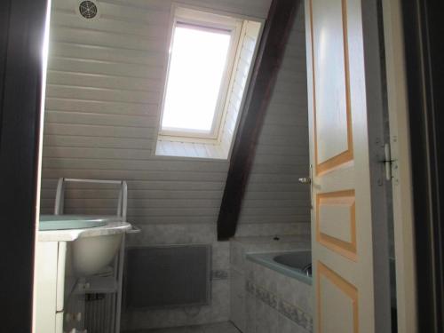ein Badezimmer mit Badewanne und Waschbecken und einem Fenster in der Unterkunft Gîte de France Gite de la genette 3 épis - Gîte de France 8 personnes MAE-0024 in Beyssenac