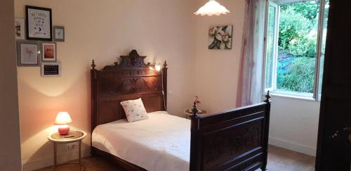 a bedroom with a wooden bed and a window at Gîte de France à Allassac 3 épis - Gîte de France 4 personnes MAE-9994 in Allassac