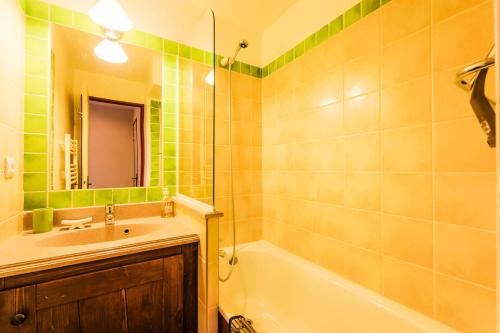 une salle de bain avec un lavabo, une baignoire et un miroir dans l'établissement Résidence L'Alpaga - maeva Home - Appartement 2 pièces 5 personnes Confort MAE-1867, à La Salle Les Alpes