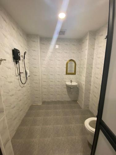 ein Bad mit einer Dusche und einem WC in der Unterkunft Hotel Apsara Temerloh Gateway in Temerloh