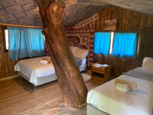 Cette chambre comprend 2 lits et un arbre. dans l'établissement Sunthalia Olympos Bungalow, à Kumluca