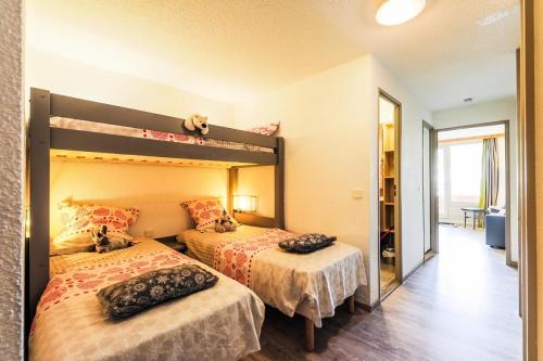 a bedroom with two beds and a mirror at Résidence Les Bergers - maeva Home - Studio 4 personnes - Sélection MAE-6894 in LʼHuez