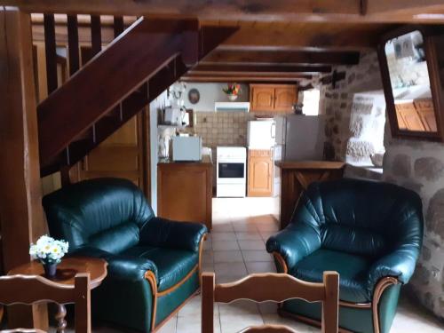 Il comprend un salon avec deux fauteuils en cuir et une cuisine. dans l'établissement Gîte de France à Saint-Cirgues-la-Loutre 3 épis - Gîte de France 2 personnes MAE-0054, à Saint-Cirgues-la-Loutre