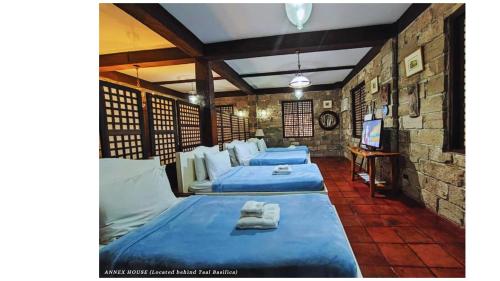 a room with three beds and a tv in it at Paradores Del Castillo in Taal