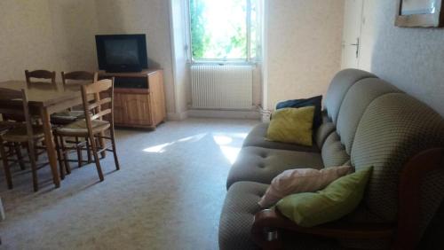 un salon avec un canapé et une table dans l'établissement Gîte de France à Curemonte 2 épis - Gîte de France 4 personnes MAE-0004, à Curemonte