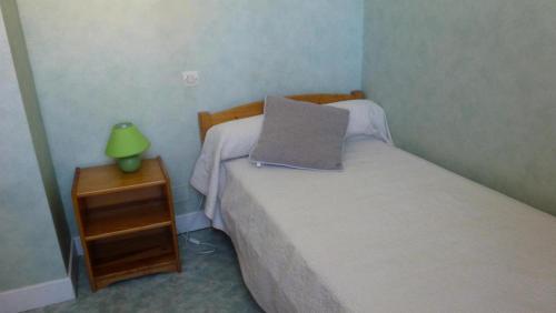 a bedroom with a bed with a pillow and a nightstand at Gîte de France à Curemonte 2 épis - Gîte de France 4 personnes MAE-0004 in Curemonte