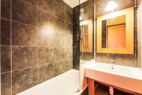 une salle de bain avec un lavabo, une baignoire et un miroir dans l'établissement Résidence L'Ours Blanc - maeva Home - Studio 4 personnes - Confort MAE-9906, à Huez