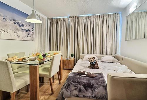 a room with a table and a dog sitting on a bed at Résidence Home Club - Studio pour 4 Personnes 71 in Tignes