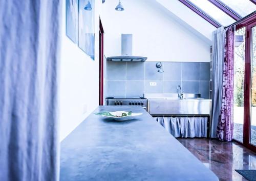 a kitchen with a long counter and a sink at Gîte de France De chapdevialle la croisée des vents 4 épis - Gîte de France 12 personnes MAE-0064 in Juillac