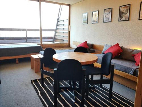 een kamer met een tafel en stoelen en een bank bij Résidence Adret - Studio pour 4 Personnes 76 in Arc 1600