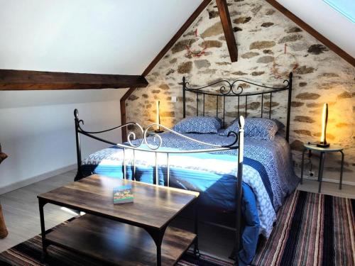 - une chambre avec un lit noir et une table dans l'établissement Gîte de France Du tilleul 3 épis - Gîte de France 4 personnes MAE-0084, à Saint-Paul