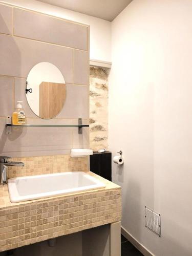 La salle de bains est pourvue d'une baignoire blanche et d'un miroir. dans l'établissement Gîte de France Du tilleul 3 épis - Gîte de France 4 personnes MAE-0084, à Saint-Paul