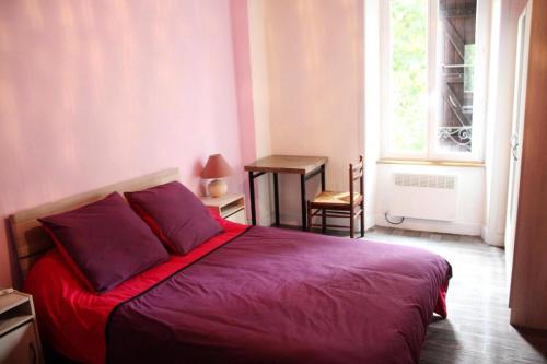 Cama roja en habitación con ventana en Gîte de France à Alleyrat 3 épis - Gîte de France 6 personnes 094, en Alleyrat