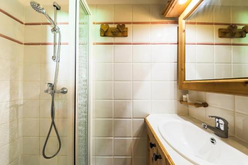 y baño con ducha y lavamanos. en Résidence Les Fermes de Méribel - maeva Home - Appartement 3 pièces 5 pers 87 en Les Allues
