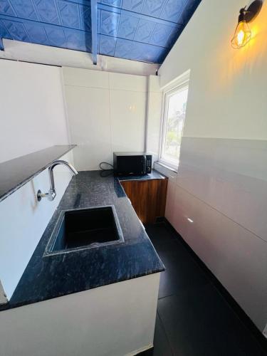 a small kitchen with a counter and a sink at Shree Kalya Resort- Chikmagalur in Chikmagalūr