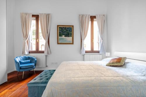a bedroom with a large bed and a blue chair at Palazzo Boito Luxury Apartment Lido Venice view Loc14132 in Venice-Lido