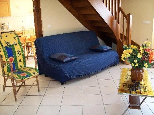 eine blaue Couch und ein Stuhl im Wohnzimmer in der Unterkunft Gîte de France à Le Chastang 3 épis - Gîte de France 6 personnes 114 in Le Chastang