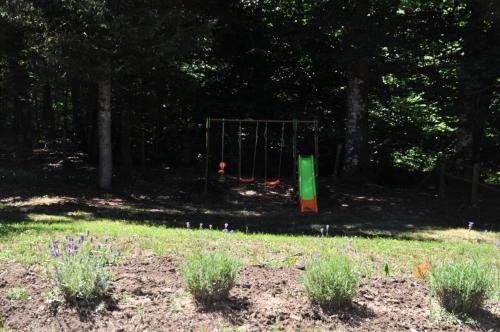 a park with a swing set in the woods at Gîte de France Le fournil de paulette et guy 4 épis - Gîte de France 6 personnes MAE-0154 in Bonnefond