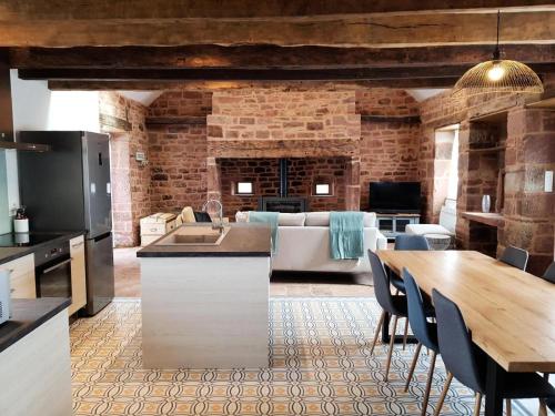 une cuisine et un salon avec une table et un canapé dans l'établissement Gîte de France Le grand frêne 4 épis - Gîte de France 6 personnes MAE-0164, à Lanteuil