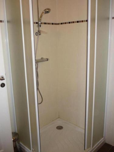 a shower with a glass door in a bathroom at Gîte de France à Vars-sur-Roseix 3 épis - Gîte de France 9 personnes MAE-0184 in Vars-sur-Roseix