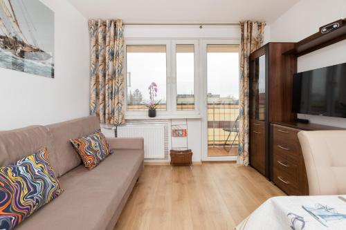 sala de estar con sofá y TV en Apartment with 2 Bedroom & Balcony Gdańsk Near The Old Town by Renters en Gdansk
