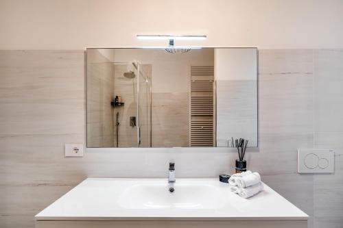 a white bathroom with a sink and a mirror at Palazzo Boito Luxury Apartment Lido Venice view Loc14132 in Venice-Lido