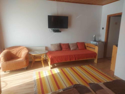 a living room with a red couch and a table at Attila's Guest House in Budaörs