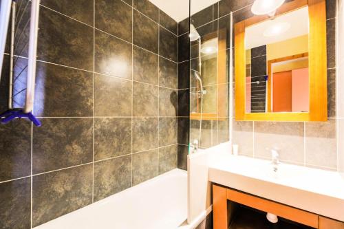 La salle de bains est pourvue d'une douche, d'un lavabo et d'un miroir. dans l'établissement Résidence L'Ours Blanc - maeva Home - Studio 5 personnes Sélection 12, à Huez
