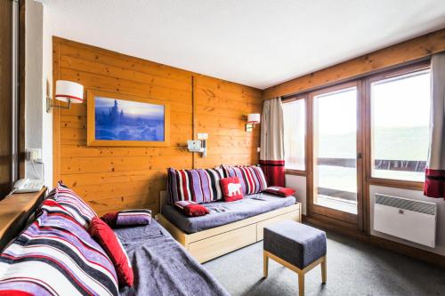 un salon avec un canapé et une fenêtre dans l'établissement Résidence L'Ours Blanc - maeva Home - Appartement 2 pièces 4 personnes Sélection MAE-5256, à Huez