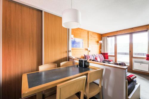 une salle à manger avec une table et des chaises dans l'établissement Résidence L'Ours Blanc - maeva Home - Appartement 2 pièces 4 personnes Sélection MAE-5256, à Huez