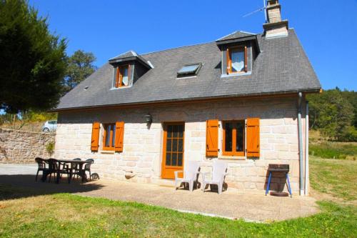 a small brick house with a table and chairs at Gîte de France à Toy-Viam 3 épis - Gîte de France 4 personnes MAE-0254 in Tarnac