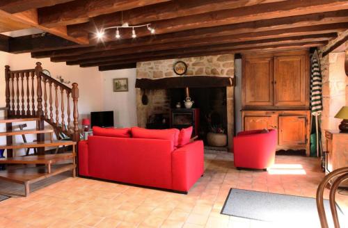 - un salon avec un canapé rouge et une cheminée dans l'établissement Gîte de France à Toy-Viam 3 épis - Gîte de France 4 personnes MAE-0254, à Tarnac