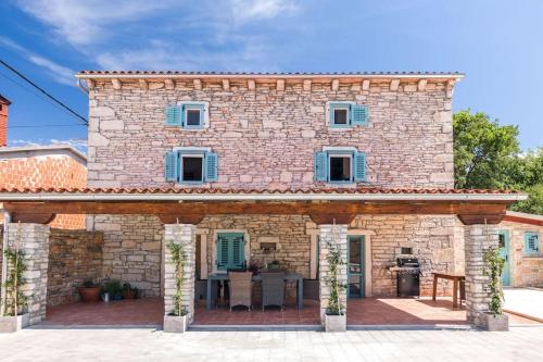 a large stone house with a patio at Villa La Musica by Istrialux in Čabrunići