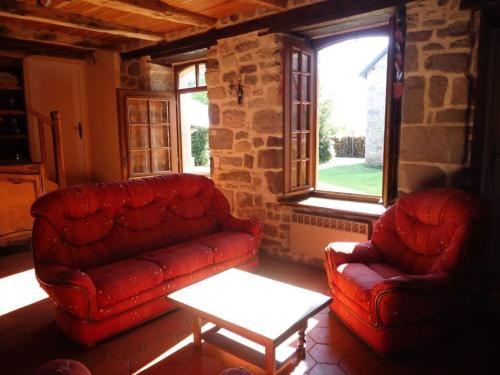 ein Wohnzimmer mit zwei roten Sofas und einem Tisch in der Unterkunft Gîte de France La bachellerie 2 épis - Gîte de France 5 personnes 264 