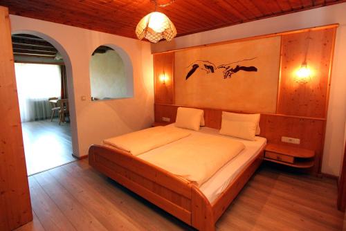 a bedroom with a bed with birds on the wall at Hotel Forsthof in Sankt Johann im Pongau