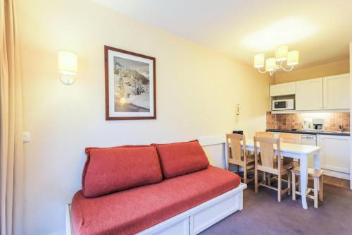 un salon avec un canapé rouge et une table dans l'établissement Résidence Le Thabor - maeva Home - Appartement 2 Pièces 5 Personnes Confort MAE-5667, à Le Désert