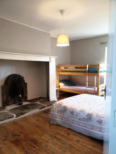 une chambre avec deux lits superposés et une cheminée dans l'établissement Gîte de France Les embruns 3 épis - Gîte de France 6 personnes MAE-0284, à Altillac