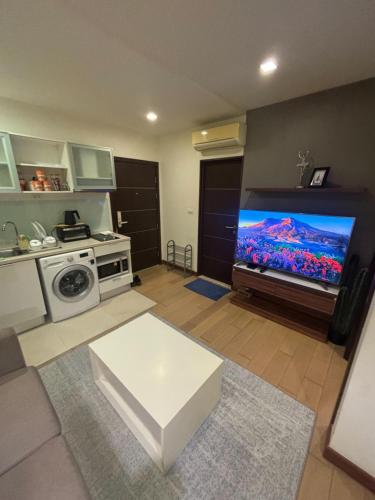 a living room with a large flat screen tv at The Astra Bee friend in Chiang Mai
