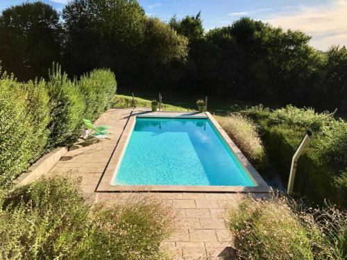 a swimming pool in the middle of a garden at Gîte de France A perle de vue épis - Gîte de France 294 in Uzerche