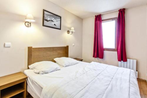 - une chambre avec un grand lit blanc et des rideaux rouges dans l'établissement Résidence L'Albane - maeva Home - Appartement 2 pièces 5 personnes Prestige MAE-5674, à Vars