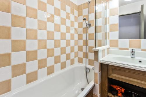 une salle de bain avec une baignoire blanche et un lavabo dans l'établissement Résidence L'Albane - maeva Home - Appartement 2 pièces 5 personnes Prestige MAE-5674, à Vars