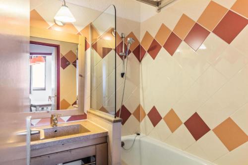 une salle de bain avec un lavabo, un miroir et une baignoire dans l'établissement Résidence Les Fontaines Blanches - maeva Home - Appartement 2 pièces 5 personnes Confort MAE-2329, à Morzine